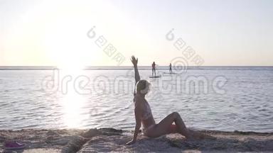 海滩上一位穿比基尼的女士正在海上冲浪板上向两位女士挥手